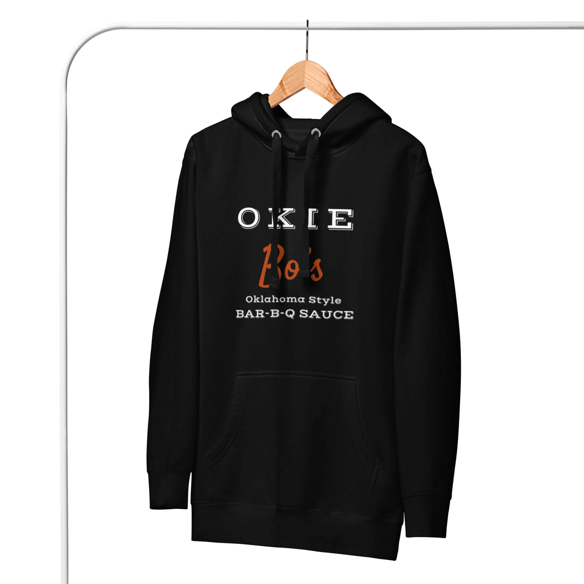 Okie Bo's black unisex hoodie with Oklahoma Style Bar-B-Q Sauce logo front view hanging on wooden hanger